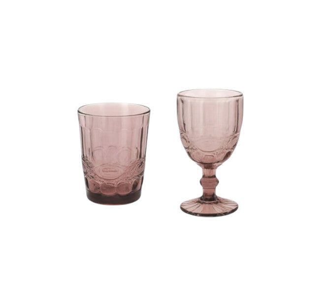 Set di bicchieri tumbler e calici goblet in vetro rosa lavorato e stile retrò, Madame, a noleggio a Roma.
